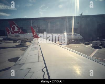 Aile d'avion de Turkish Airlines, avions sur le terrain d'aviation et bâtiment du terminal du Grand aéroport d'Istanbul. Vue depuis le hublot. Istanbul, Turquie - février 2023 Banque D'Images