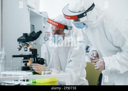 Les travailleuses médicales en uniforme de protection travaillent sur le vaccin COVID-19 Banque D'Images