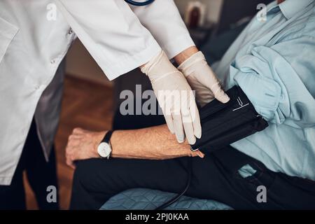 Médecin soignant le test de tension artérielle et la fréquence cardiaque de l'homme âgé. Vérification de l'état de santé du patient aîné souffrant d'hypertension artérielle Banque D'Images