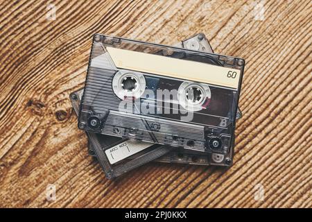 Cassettes à bande. Cassettes magnétiques sur table en bois. Style de musique rétro. fête musicale des années 80. Style vintage. Équipement analogique. Son stéréo Banque D'Images