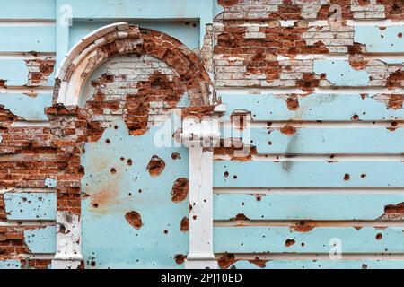 19 mars 2023, Izium, oblast de Kharkiv, Ukraine: Mur d'une maison de ville montrant des dégâts causés par l'explosion et des trous de balle. Izyum dans la région de Kharkiv en Ukraine, six mois après le retrait de l'armée russe. Bien que la ville ne soit plus en feu, il existe encore un risque élevé d'explosions dues à la présence de mines, de câbles trip et de munitions non explosées. Izyum a été libéré le 10 septembre 2022 lors d'une contre-offensive des forces armées ukrainiennes, mais la ville a été gravement endommagée par les bombardements et l'occupation russes, avec 80% des bâtiments endommagés. Tombes massives de civils et de soldats ukrainiens, y compris Banque D'Images