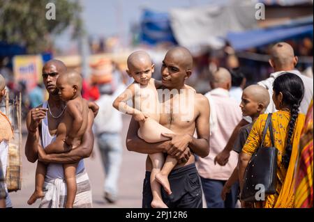 Haridwar, Uttarakhand, Inde - octobre 2022: Portrait d'un homme non identifié portant son enfant dans les bras après le rasage de leur tête a une partie du rituel. Banque D'Images