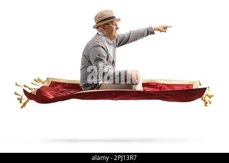 Photo de profil d'un homme âgé volant avec un tapis de velours rouge et pointant isolé sur fond blanc Banque D'Images