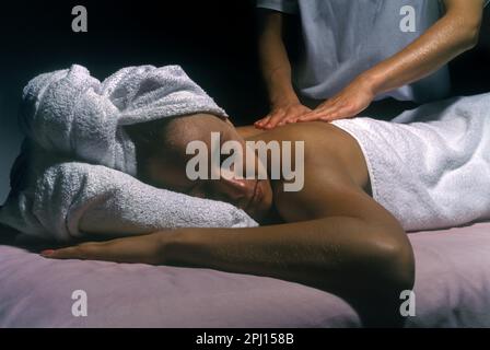 Jeune femme portant AVOIR MASSAGE DOS DE MASSOTHÉRAPEUTE Banque D'Images