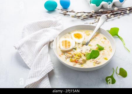 Soupe aigre polonaise traditionnelle Zurek fait avec de la farine de rayon, du g et des légumes sur la table de cuisine avec décoration de Pâques Banque D'Images