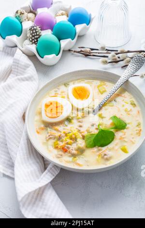 Soupe aigre polonaise traditionnelle Zurek fait avec de la farine de rayon, du g et des légumes sur la table de cuisine avec décoration de Pâques Banque D'Images