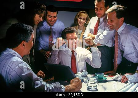 1994 UN PETIT GROUPE D'EMPLOYÉS DE BUREAU SOURIANTS ET HISTORIQUES LORS D'UNE RÉUNION Banque D'Images