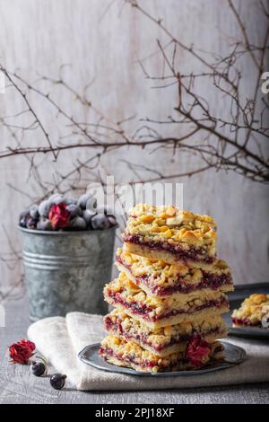 Tarte au streusel avec remplissage de cassis et de pétales de rose sur un fond clair. Banque D'Images