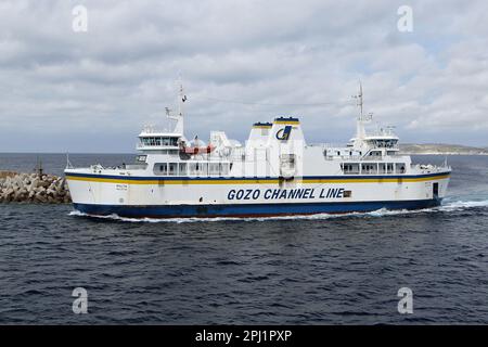 Un ferry traversant le canal de Gozo, qui est un court tronçon de la mer Méditerranée séparant l'île maltaise de Gozo de la pointe nord de Malte. Elle mesure environ 7 km (4,3 mi) de long et sa largeur varie de 6,7 km (4,2 mi) à son extrémité la plus large à 4,5 km (2,8 mi) à son extrémité nord-est Au centre du chenal se trouvent les deux îles de Comino (habitée) et Cominotto. Le canal sert de liaison maritime entre les deux îles avec un service de ferry dirigé par la ligne de canal Gozo qui fonctionne toute l'année depuis les ports de Mġarr Harbour et Ċirkewwa. Banque D'Images