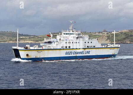 Un ferry traversant le canal de Gozo, qui est un court tronçon de la mer Méditerranée séparant l'île maltaise de Gozo de la pointe nord de Malte. Elle mesure environ 7 km (4,3 mi) de long et sa largeur varie de 6,7 km (4,2 mi) à son extrémité la plus large à 4,5 km (2,8 mi) à son extrémité nord-est Au centre du chenal se trouvent les deux îles de Comino (habitée) et Cominotto. Le canal sert de liaison maritime entre les deux îles avec un service de ferry dirigé par la ligne de canal Gozo qui fonctionne toute l'année depuis les ports de Mġarr Harbour et Ċirkewwa. Banque D'Images