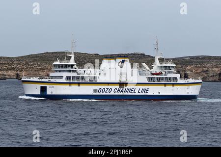 Un ferry traversant le canal de Gozo, qui est un court tronçon de la mer Méditerranée séparant l'île maltaise de Gozo de la pointe nord de Malte. Elle mesure environ 7 km (4,3 mi) de long et sa largeur varie de 6,7 km (4,2 mi) à son extrémité la plus large à 4,5 km (2,8 mi) à son extrémité nord-est Au centre du chenal se trouvent les deux îles de Comino (habitée) et Cominotto. Le canal sert de liaison maritime entre les deux îles avec un service de ferry dirigé par la ligne de canal Gozo qui fonctionne toute l'année depuis les ports de Mġarr Harbour et Ċirkewwa. Banque D'Images