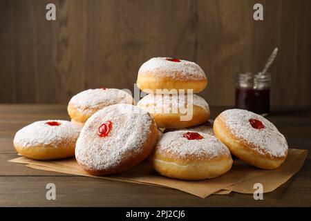 Beaucoup de délicieux beignets avec de la gelée et du sucre en poudre sur une table en bois Banque D'Images