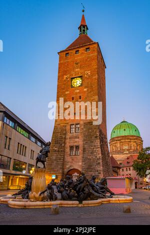 Nürnberg, Allemagne, 11 août 2022 : vue au lever du soleil sur la fontaine d'ehekarussell et la tour blanche de Nuremberg, Allemagne. Banque D'Images