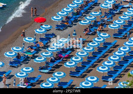 Positano, Italie, 21 mai 2022 : parasols bleus et blancs sur la plage de Positano en Italie. Banque D'Images