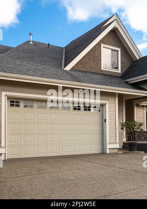 Porte de garage. Maison moderne avec porte de garage qui est fermée. Un quartier parfait. Maison familiale avec grande porte de garage et allée en béton devant. Banque D'Images