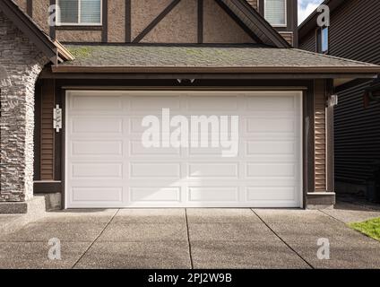 Porte de garage. Maison moderne avec porte de garage qui est fermée. Un quartier parfait. Maison familiale avec grande porte de garage et allée en béton devant. Banque D'Images