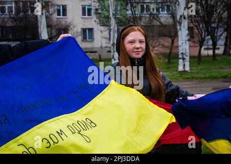 Les femmes se rassemblent sur le côté de la route avec des drapeaux ukrainiens pour encourager les soldats qui vont au Donbass sur le front pour combattre l'armée russe. C'est le cas Banque D'Images