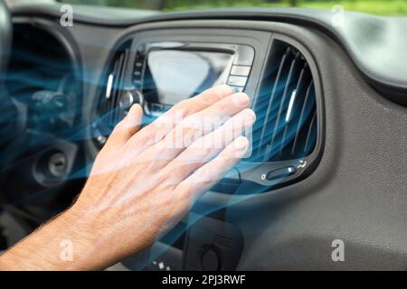 Homme vérifiant le travail du climatiseur dans la voiture et illustration du débit d'air froid, gros plan Banque D'Images