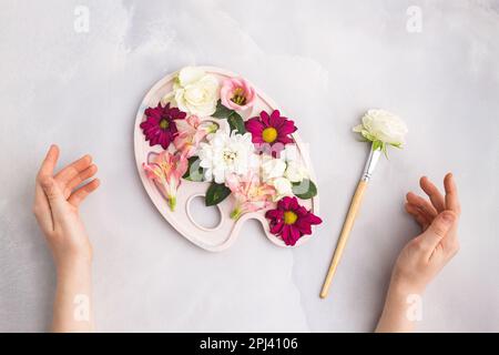 Fleurs à l'intérieur de la peinture pinceau de palette avec une fleur sur platte grise Banque D'Images