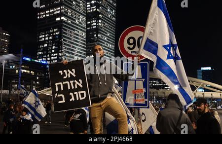 TEL AVIV, ISRAËL - MARS 30: Un partisan du Premier ministre israélien Benjamin Netanyahu détient le drapeau israélien et un panneau qui se lit "Je suis un citoyen de seconde classe" comme d'autres mars et bloquer l'autoroute Ayalon, l'une des principales autoroutes d'Israël, Au cours d'un rassemblement en faveur de la coalition de droite israélienne et de ses propositions de modifications judiciaires concernant 30 mars 2023 à tel-Aviv, Israël. Crédit : Eddie Gerald/Alay Live News Banque D'Images