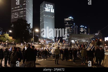 TEL AVIV, ISRAËL - MARS 30 : Les partisans du Premier ministre israélien Benjamin Netanyahu détiennent les drapeaux israéliens et marchent alors qu'ils bloquent la route d'Ayalon, l'une des principales autoroutes d'Israël, lors d'un rassemblement en faveur de la coalition de droite d'Israël et des changements judiciaires qu'elle propose d'apporter à 30 mars 2023 à tel-Aviv, en Israël. Crédit : Eddie Gerald/Alay Live News Banque D'Images