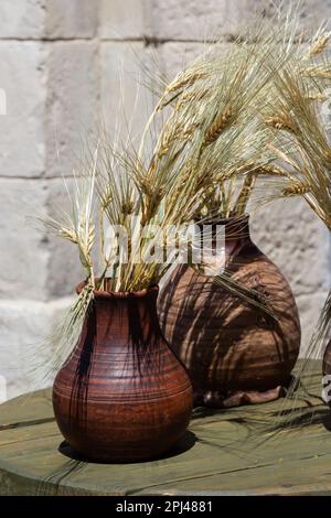 Trois pots en céramique avec des épillets, support de maïs sur le rebord de la fenêtre. Banque D'Images