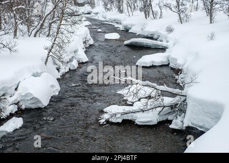 Rivière enneigée dans la région de Jotunheimen en Norvège Banque D'Images