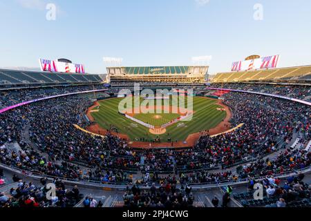 Oakland, Californie, 30 mars 2023. Oakland Athletics, Left, et Los Angeles Angels joueurs et entraîneurs se tiennent sur les lignes de base avant un match de baseball du jour d'ouverture à Oakland, en Californie, jeudi, 30 mars 2023. Banque D'Images