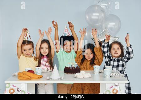 S'assoit Près De La Table Les Enfants Célébrant Une Fête D'anniversaire à L' intérieur S'amusent Ensemble