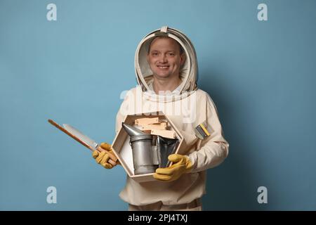 Un gardien de faisceau en uniforme avec des outils sur fond bleu clair Banque D'Images