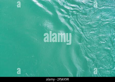 La texture des vagues de couleur turquoise de l'eau à écoulement rapide dans la rivière. Résumé de la nature. Banque D'Images