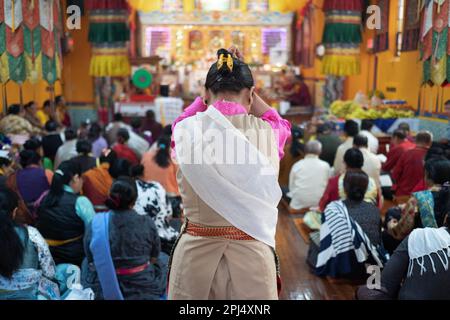 Un adorateur entrant dans le temple bouddhiste de Sherpa dans Queens s'arrête un moment de prière et de méditation. Banque D'Images