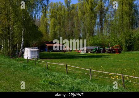 Belle campagne avec machines agricoles et panneaux solaires le jour ensoleillé du printemps Banque D'Images