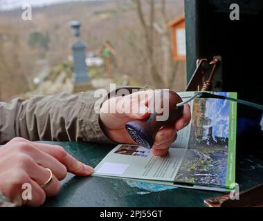 29 Mars 2023, Saxe-Anhalt, Alexisbad: Un randonneur marque son livret de randonnée à un point de vue de la Wandernadel Harzer dans la vallée de Selke. Pour la première fois, le Harzer Wandernadel a publié un livret d'accompagnement pour la vallée de Selke. Ici, les randonneurs peuvent découvrir la nature avec des paysages variés sur le sentier de randonnée longue distance de 75 kilomètres. Divisé en six étapes, 17 timbres peuvent être recueillis le long du chemin mystique. À la fin, vous êtes récompensé par le pin de randonnée sous la forme d'un kingfisher, qui peut même être observé par des randonneurs attentifs dans son environnement naturel. La saison 16th openin Banque D'Images