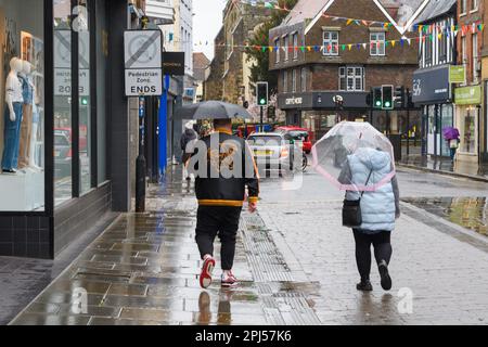 Salisbury, Wiltshire, Royaume-Uni, 31st mars 2023 : personnes sur High Street avec parasols par temps humide et venteux le dernier jour de mars. Crédit : Paul Biggins/Alamy Live News Banque D'Images