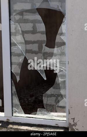 trou de balle dans le verre est un trou de balle réel d'une balle de projectile de grand calibre. Porte vitrée percée d'une balle pendant la guerre, attaque terroriste. Brok Banque D'Images