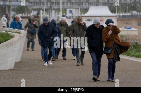 Un groupe de personnes brave la pluie et les vents forts sur la promenade de Douvres, dans le Kent. Date de la photo: Vendredi 31 mars 2023. Banque D'Images