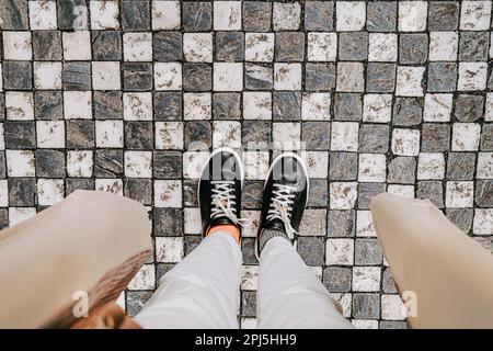 Jambes de femme en baskets sur pavés. Femme pieds vue de dessus. Rue Prague Banque D'Images