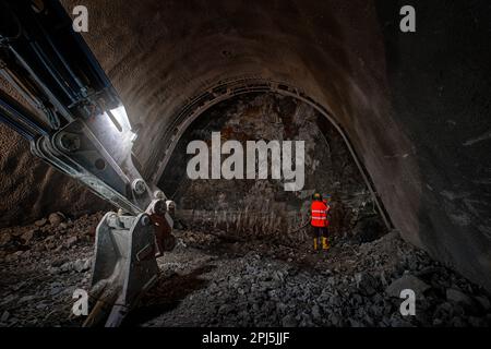 Construction de métro souterrain. Homme dans le travail avec gilet orange et casque dur sur le rocher (ardoise et quartzite). Future ligne de métro 'd' à Prague, Czec Banque D'Images