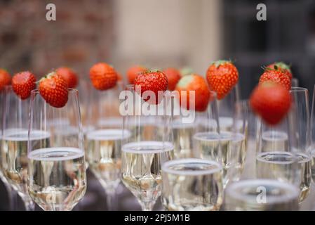 De nombreuses coupes de champagne décorées de fraises lors d'une cérémonie de mariage Banque D'Images
