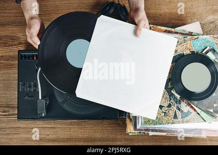 Homme écoutant de la musique à partir d'un disque vinyle. Lecture de musique à partir d'un disque analogique sur le lecteur de platine. Écouter de la musique de l'ancienne collection. Détente à la maison. Réf Banque D'Images