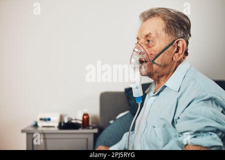 Homme âgé inhalant des voies respiratoires et des poumons appliquant des médicaments. Traitement Covid-19 ou coronavirus. Homme respirant à travers le masque facial à l'aide d'un nébuliseur Banque D'Images