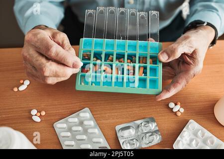 Homme senior organisant son médicament en distributeur de pilules. Homme senior prenant des pilules de la boîte. Santé et vieux concept avec des médicaments. Médicaments Banque D'Images