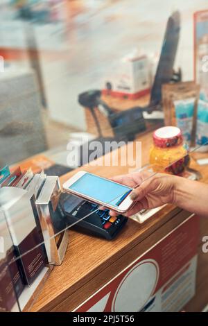 Femme payant des médicaments à la pharmacie en utilisant le mode de paiement sans contact par téléphone portable. Femme utilisant un nouveau mode de paiement Banque D'Images