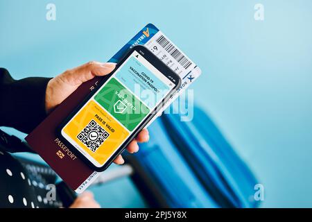 Certificat numérique Covid. Carte numérique de vaccination Covid. Femme passager tenant une carte médicale numérique sur son téléphone portable, son passeport et son avion TIC Banque D'Images