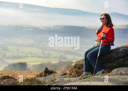 Jeune femme prenant dans la vue sur Bamford Edge dans le parc national de Peak District Banque D'Images