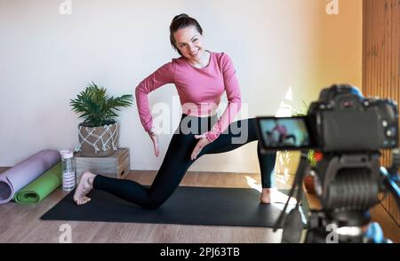 Une enseignante de fitness enregistre des conseils vidéo d'entraînement pour ses abonnés. Banque D'Images