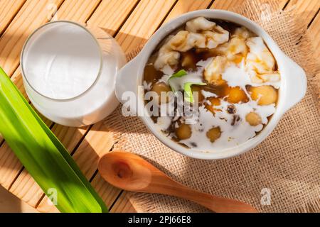 Bubur Sumsum ou Candil porridge, farine de riz indonésienne porridge avec des boules de riz sucrées de patate douce, servi avec de la sauce au sucre de palme dans un bol blanc Banque D'Images