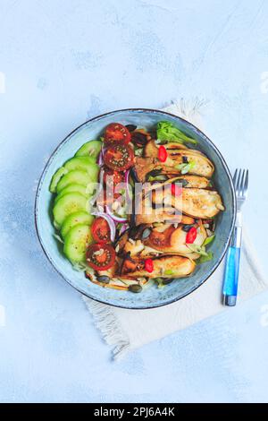 Bol à salade avec rôtissoire, champignons d'huîtres, tomate, concombre et oignon rouge. Repas sain de légumes Banque D'Images