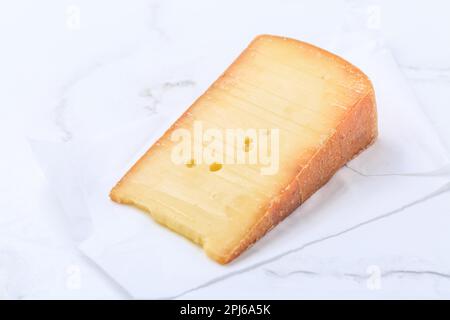 Morceau de fromage sur papier blanc Banque D'Images